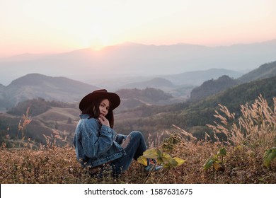 A beautiful woman sitting and enjoying the mountain view