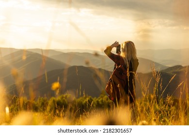 Beautiful woman sitting on mountain top and contemplating landscape. - Shutterstock ID 2182301657
