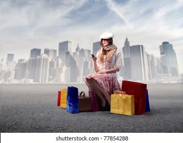 Beautiful Woman Sitting On A Street And Surrounded By Shopping Bags