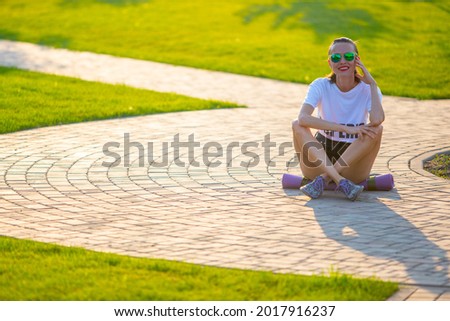 Foto Bild Junger Mann fährt auf dem Skate und hält Surfbrett.