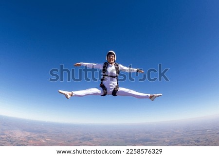 Beautiful woman skydiving in freefall, freestyle position.