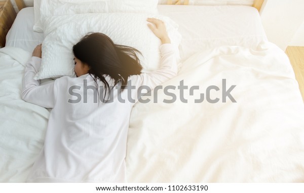 寝室で眠る美しい女性 女性は寝台の上で顔を伏せて寝る 女の子は朝白い部屋のベッドでパジャマを着て寝る 暖かい音 の写真素材 今すぐ編集
