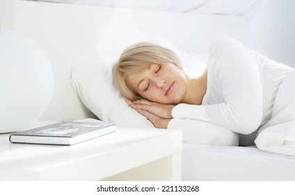 Beautiful woman sleeping in white bed