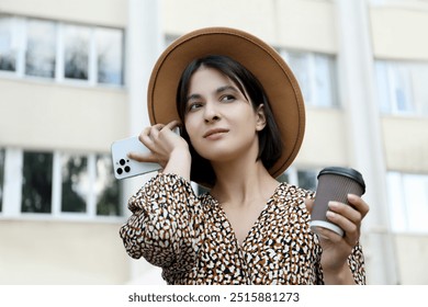 Beautiful woman with smartphone listening to voice message outdoors, low angle view - Powered by Shutterstock