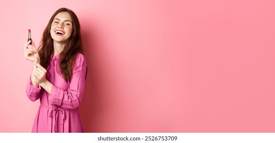 Beautiful woman smiling, applying lipstick and make up for party, standing against pink background, getting ready for going out. - Powered by Shutterstock