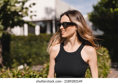 Beautiful Woman Smiling And Turn Around Head In Countryside. Portrait Of A Smiling Blonde Girl In Black Glasses. Happy Cheerful Girl Laughing, Look Fashion And Show Toothy Smile. Flying Hair.