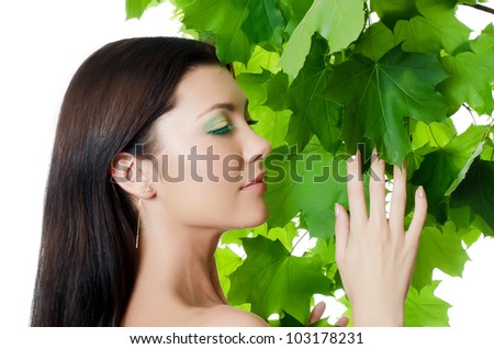 Beautiful woman with spring green leaves. Skincare