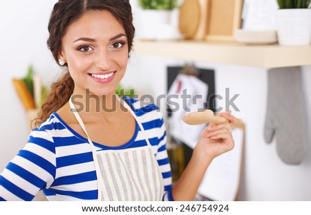 Beautiful woman standing in kitchen with apron