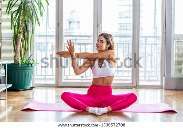Beautiful woman stretching arms . Fitness\
female doing warmup workout. Fitness woman doing stretch exercise\
stretching her arms - tricep and shoulders stretch . Fit girl\
living an active\
lifestyle.