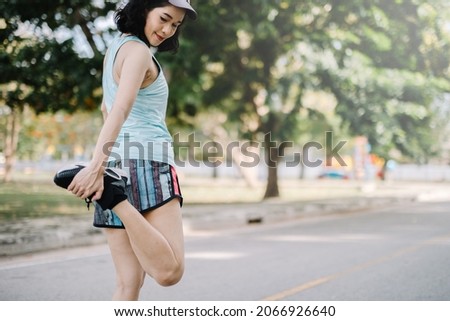 A beautiful woman stretching her body before running in the morning with a bright smile on her face. women's health care concept