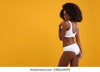 Beautiful woman in stylish bikini on yellow background, space for text