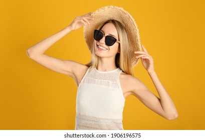 Beautiful woman in stylish sunglasses on yellow background