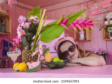 Beautiful Woman With Sunglasses And A Centerpiece With Tropical Fruits And Flowers. Joy, Exoticism And Color Of Summer