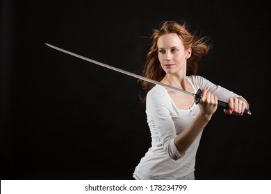 Beautiful woman with a sword, blade is slightly blurred