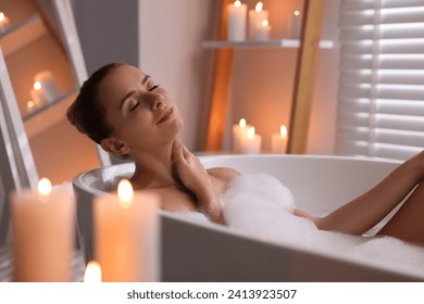 Beautiful woman taking bath in tub with foam indoors. Romantic atmosphere - Powered by Shutterstock