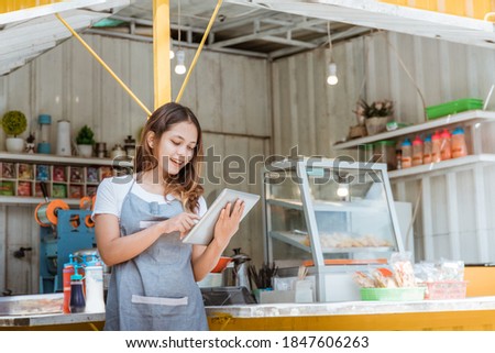 beautiful woman taking online order at her small stall shop. young small business owner