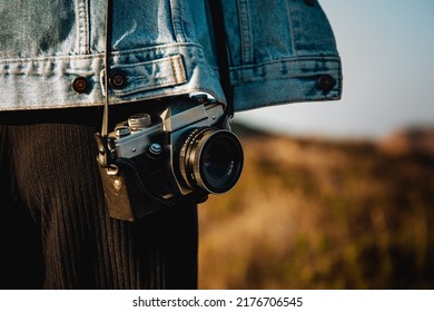 Beautiful woman taking picture outdoors with a analog camera - Powered by Shutterstock