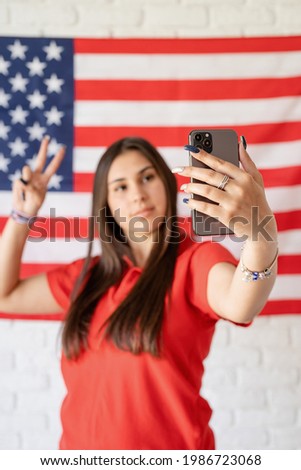 Beautiful woman taking a selfie on the USA flag background