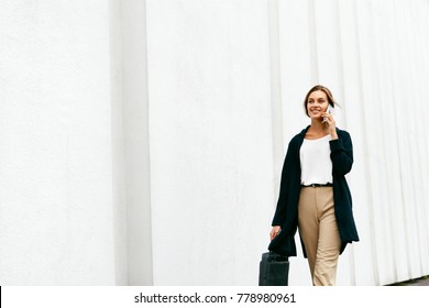 Beautiful Woman Talking On Phone Walking On Street. Portrait Of Stylish Smiling Business Woman In Fashionable Clothes Calling On Mobile Phone Near Office. Female Business Style. High Resolution.