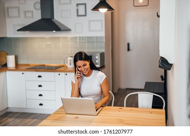 Beautiful woman talking on smart phone and using laptop at home, portrait. - Shutterstock ID 1761207977