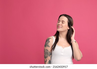 Beautiful woman with tattoos on arm against pink background. Space for text - Shutterstock ID 2162432917