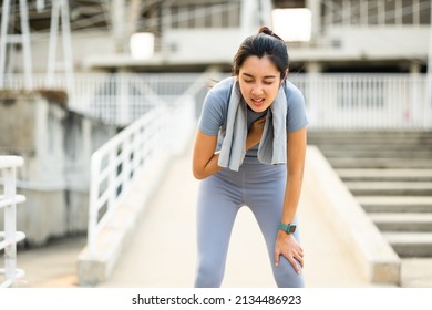 Beautiful woman tired during jogging in the city at sunrise. Young asian female intense training workout challenge breathing exhausted. Exercise in the morning. Healthy and active lifestyle concept. - Shutterstock ID 2134486923