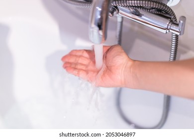 Beautiful woman touching on the surface of water in bathtub to check the water temperature before get in the bath. Wellness and hydro therapy concept. - Powered by Shutterstock