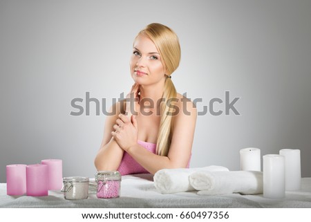 Beautiful woman in towel behind table with candles