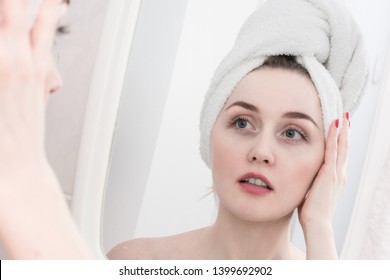 Beautiful woman with a towel on her head, reflection in the mirror, looks in the mirror, close up - Shutterstock ID 1399692902