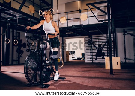 Beautiful woman training on the exercise machine in the gym.