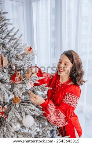 beautiful woman in ukrainian traditional clothes decorating christmas tree