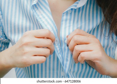 beautiful woman unbuttoning her shirt .