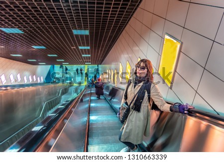Beautiful woman uses escalator to access Marmaray train in subway metro,Istanbul,Turkey.