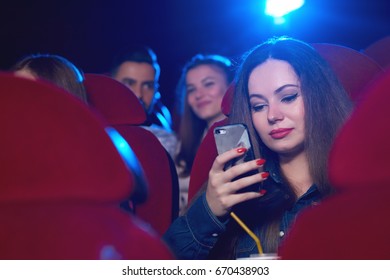 Beautiful Woman Using Her Phone During A Boring Movie At The Cinema Copyspace Technology Communication Bored Distraction Distracting Online Internet Addicted Social User Mobility Carrier.