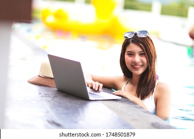 A Beautiful Woman Using Laptop While Relaxing On A Sun Lounger In The Backyard At Home. Summer Fun At Home By The Swimming Pool