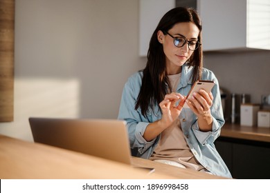 Beautiful Woman Using Mobile Phone And Laptop Computer At Home