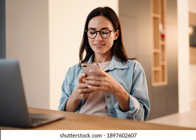 Beautiful Woman Using Mobile Phone And Laptop Computer At Home