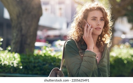 Beautiful Woman Using Smartphone Having Phone Call Talking On Mobile Phone In City Street With Morning Sun Flare