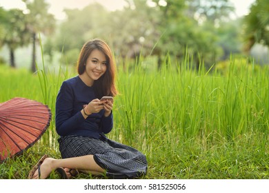 Beautiful Woman Are Using Smartphone On The Field,thai Traditional Culture,Thailand