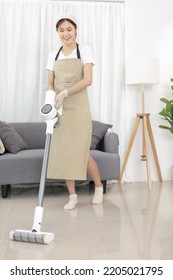 Beautiful Woman Vacuuming The Floor Of Her Living Room, Big Cleaning In The House, Removes Germs And Dirt And Deep Stains, Housewife Cleaning, Keeping Her Home Clean, Domestic Hygiene.