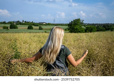 A Beautiful Woman in a Vast Yellow Flower Field Beneath a Clear Blue Sky in Summer - Powered by Shutterstock