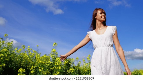 Beautiful woman walking in mustard field on a sunny day - Powered by Shutterstock