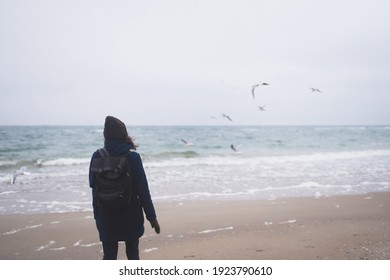 Beautiful Woman Walking On The Beach With Seagulls In Winter Time. Free Spirit Concept