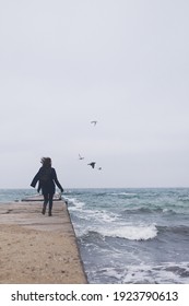 Beautiful Woman Walking On The Beach With Seagulls In Winter Time. Free Spirit Concept