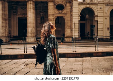 A beautiful woman walks with backpack in Turin, Italy. Beautiful historical architecture. Vacation in Italy, adventure lifestyle - Shutterstock ID 2257151775