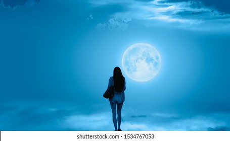 Beautiful woman walks on the clouds and Night sky with full moon "Elements of this image furnished by NASA - Powered by Shutterstock