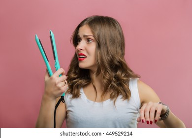 Beautiful Woman With A Wavy Hair Holding A Hair Iron