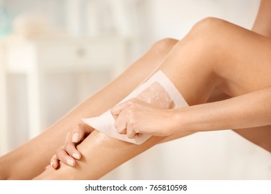 Beautiful Woman Waxing Her Legs Indoors