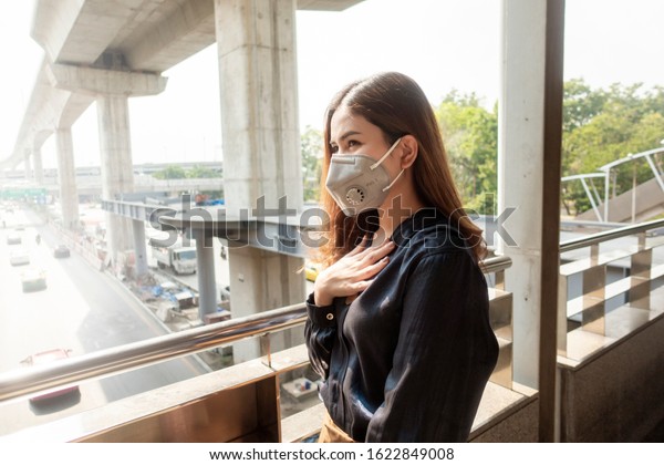 Beautiful woman wearing anti dust mask\
protect air pollution and pm 2.5 on street\
city