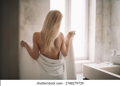 Beautiful woman wearing a bathrobe. Young happy woman enjoing in hotelroom. 